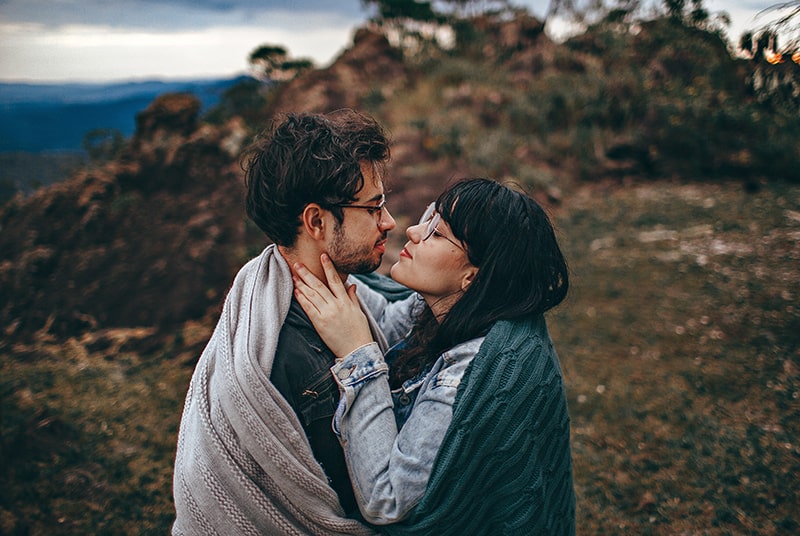 ein liebendes Paar, bedeckt mit einer Decke, die gerade geküsst wird