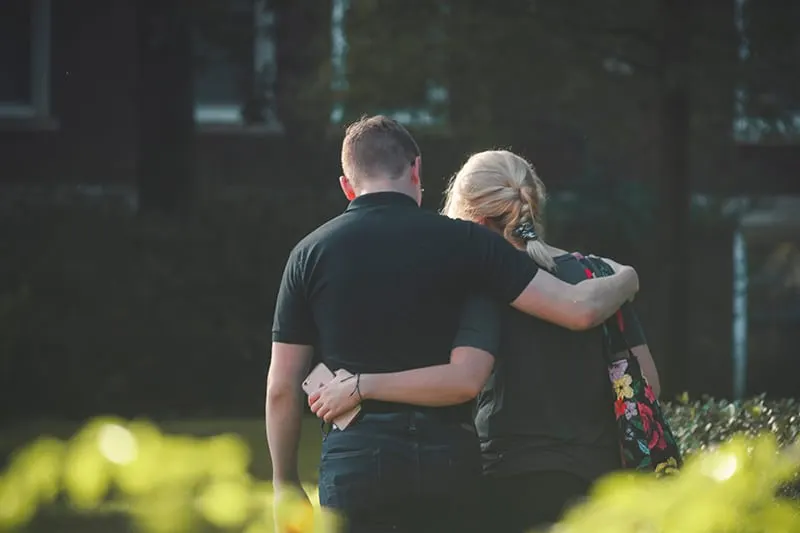 Ein Paar geht im Park spazieren und umarmt sich