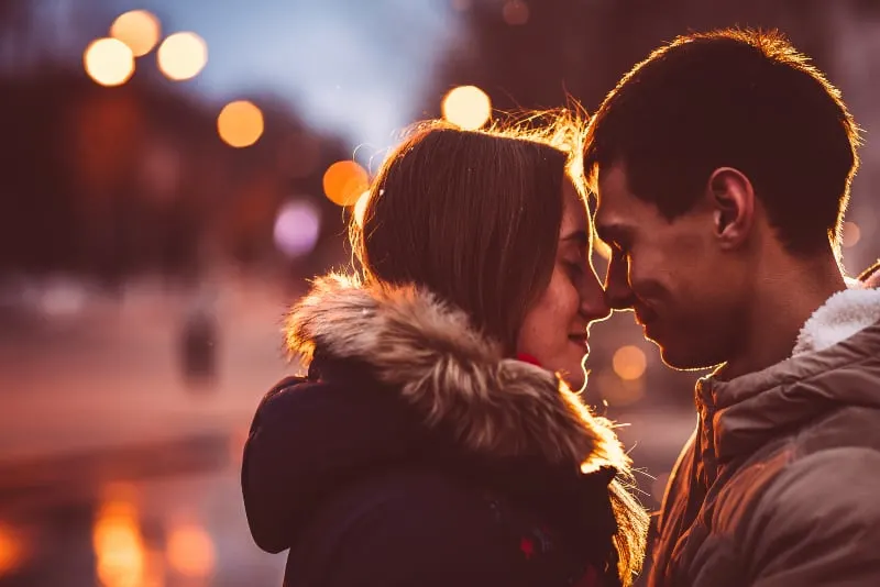 ein schönes Paar küsst unter einer Straßenlaterne