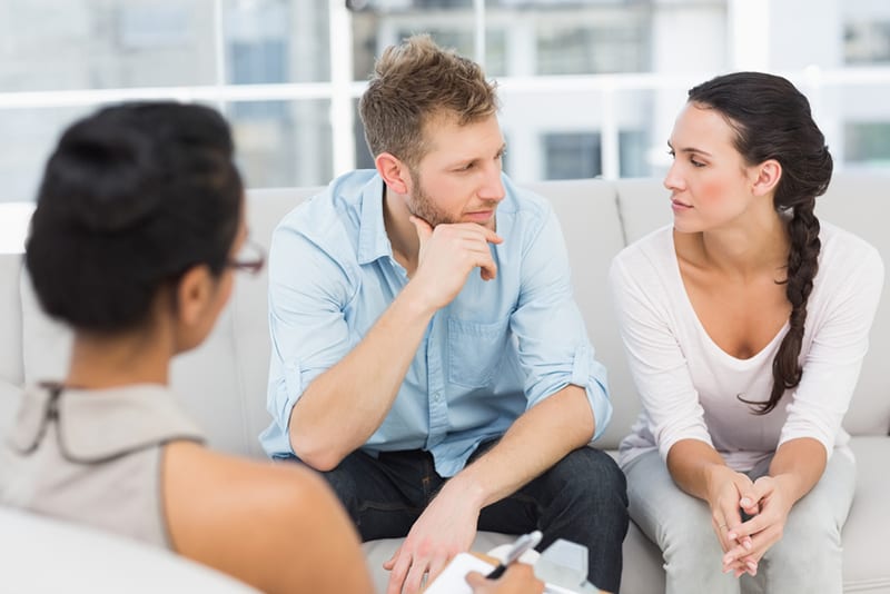 Ein Ehepaar spricht miteinander, während es vor dem Therapeuten sitzt