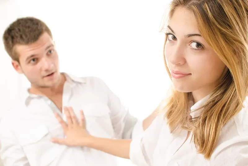 Eine Frau drückt einen Mann, der versucht, mit ihr zu sprechen