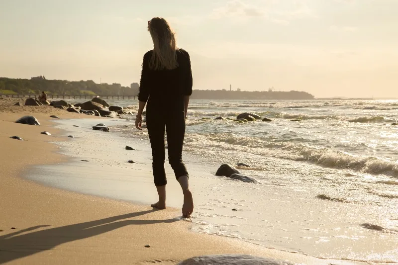 einsames Mädchen setzt am Strand