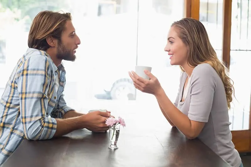 junges Paar spricht und trinkt Kaffee