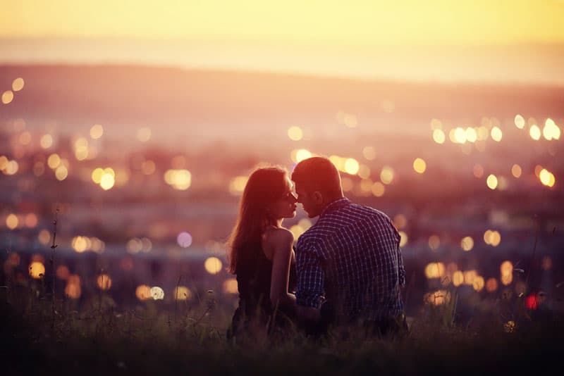 romantisches Paar, das vor Stadtblick küsst