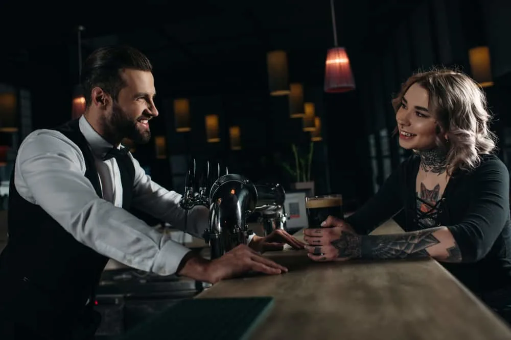 Der Kellner und der Gast der Bar flirten im Cafe