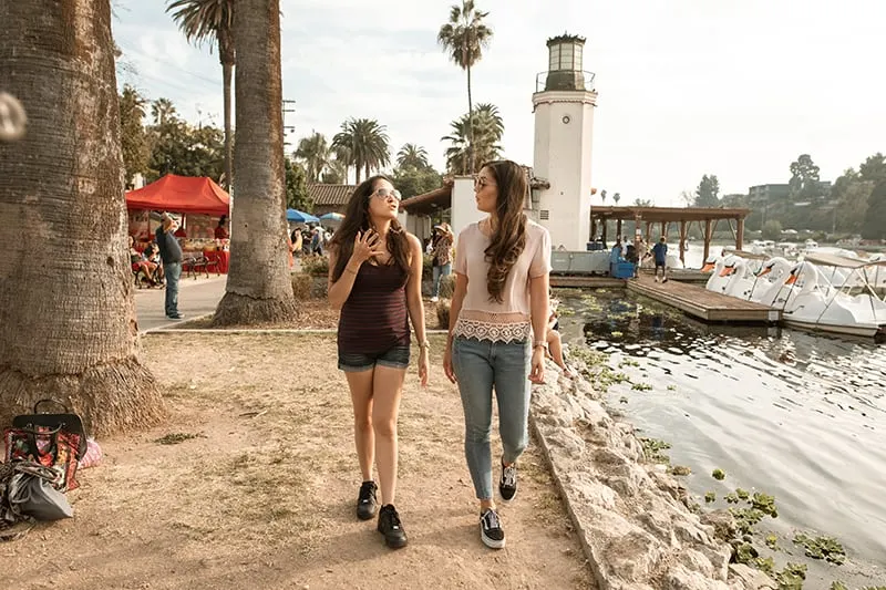 zwei Freundinnen gehen in der Nähe des Sees und reden