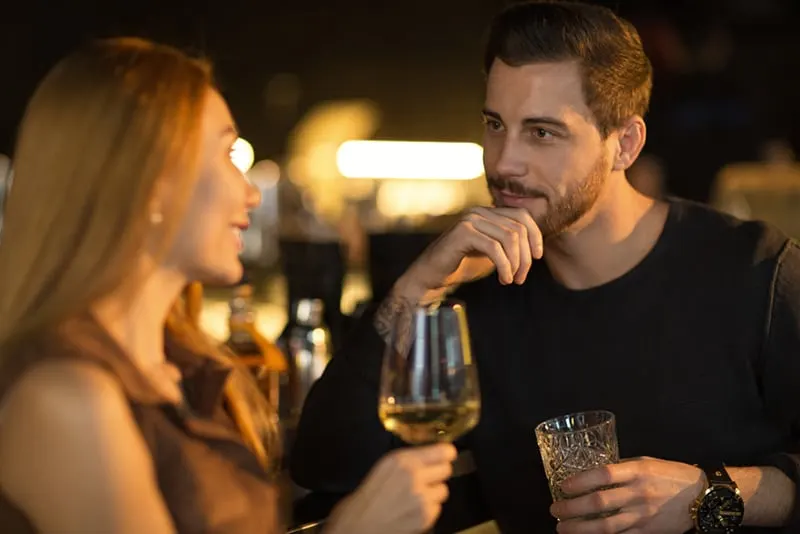 Ein Mann, der mit einer Frau flirtet und sie in der Bar ansieht