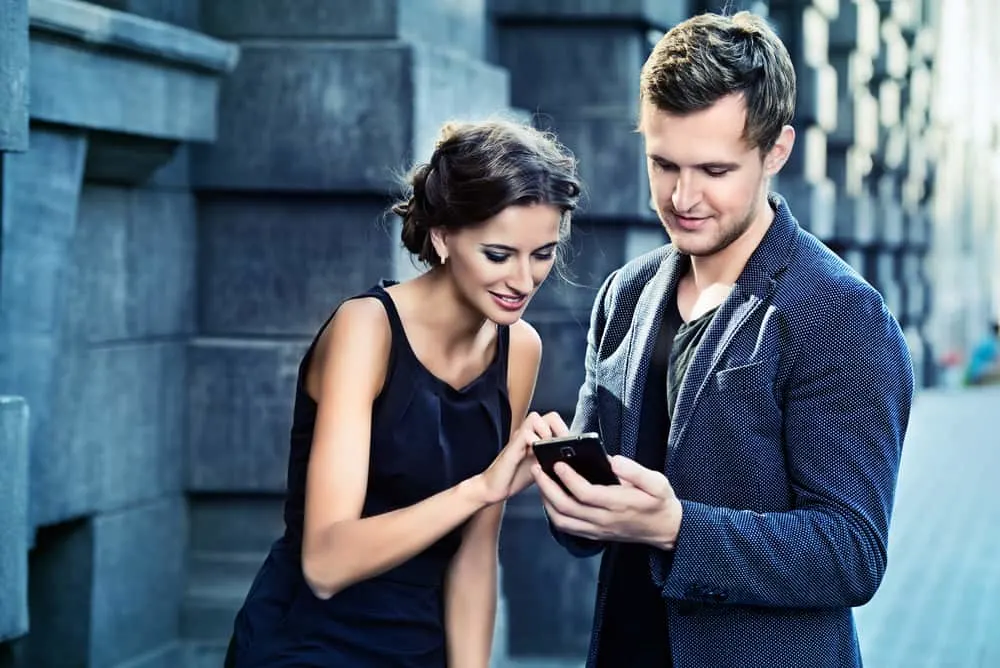 Ein Mann und eine Frau stehen auf, als sie sein Telefon berührt