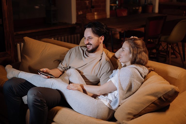 Paar kuschelt abends auf der Couch