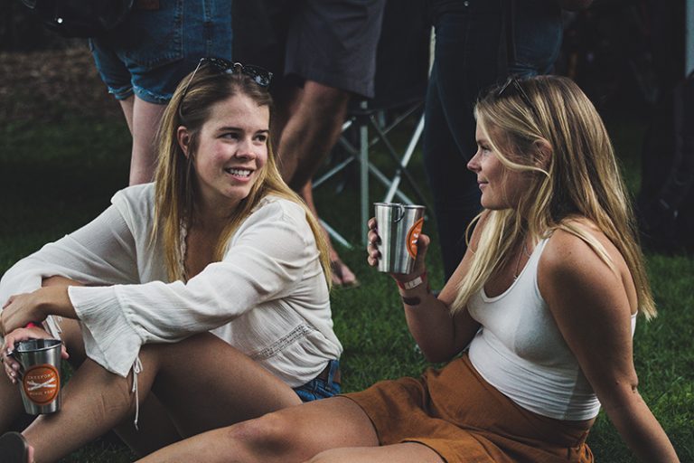 zwei Frauen sitzen im Gras und reden