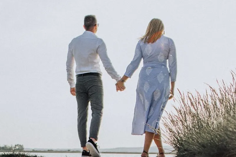 ein Mann Händchen haltend mit einer Frau am Strand