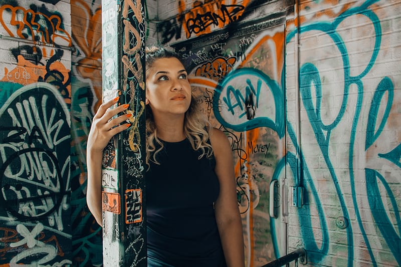 eine nachdenkliche Frau, die sich mit Graffiti an der Säule festhält