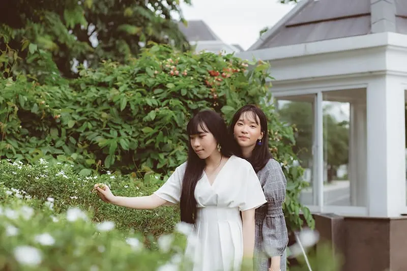 zwei Freundinnen, die tagsüber im Garten stehen