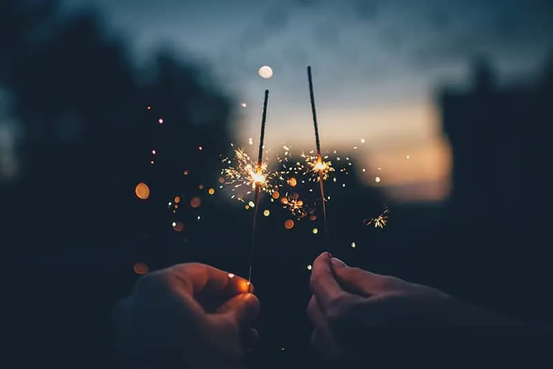 zwei Leute, die nachts Feuerwerk halten