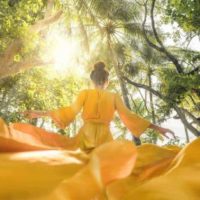 Ein Mädchen in einem gelben Kleid tanzt in der Natur