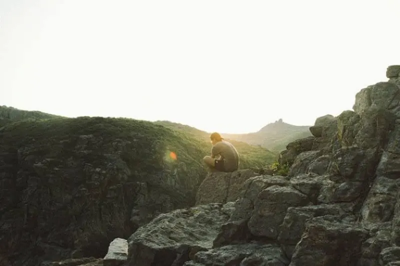 Ein einsamer Mann sitzt auf einem Hügel
