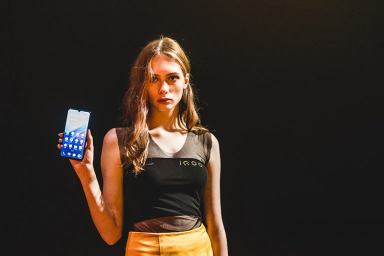 ernsthafte Frau hält zeigt ein Smartphone