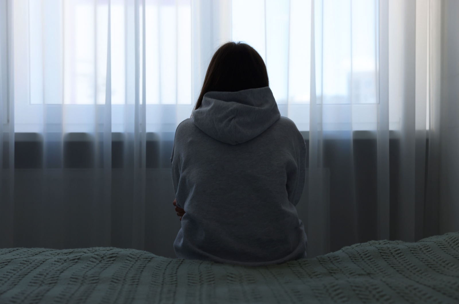 Frau sitzt auf dem Bett