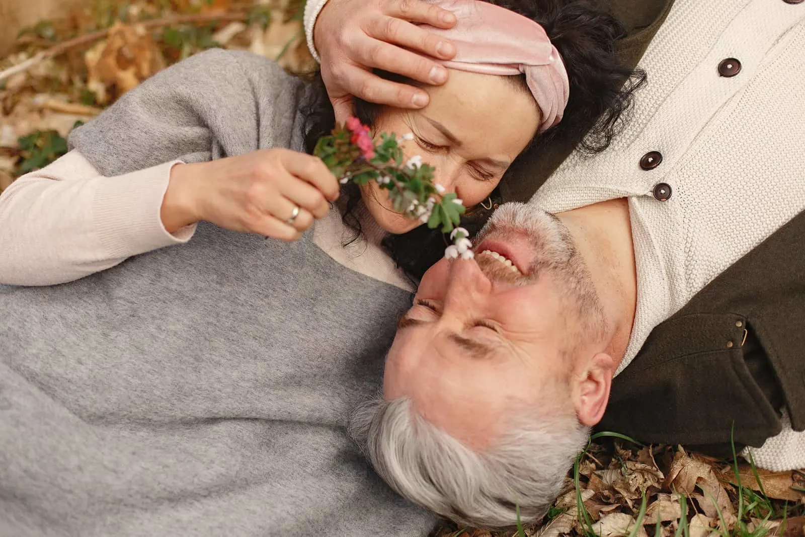 älteres verliebtes Paar, das im Gras liegt und kuschelt