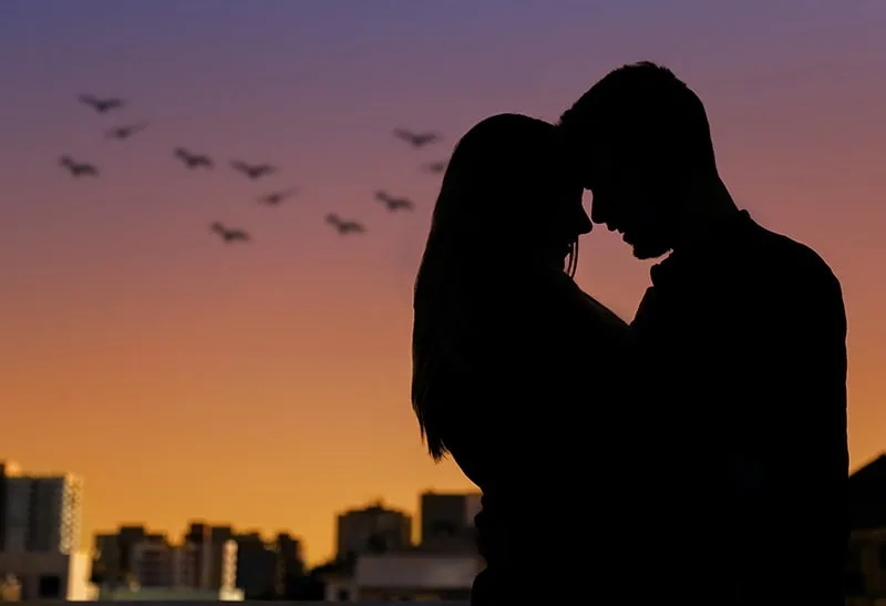 eine Silhouette eines Paares, das sich während des Sonnenuntergangs umarmt