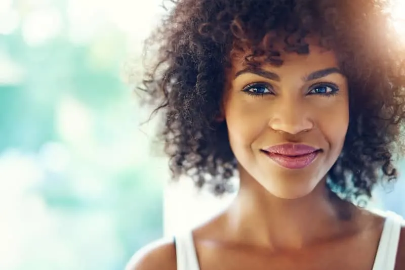 eine schöne junge schwarze Frau mit einem fröhlichen Gesichtsausdruck