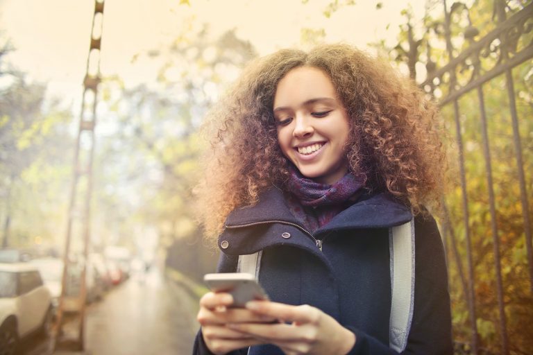 lächelnde Frau mit einem Smartphone