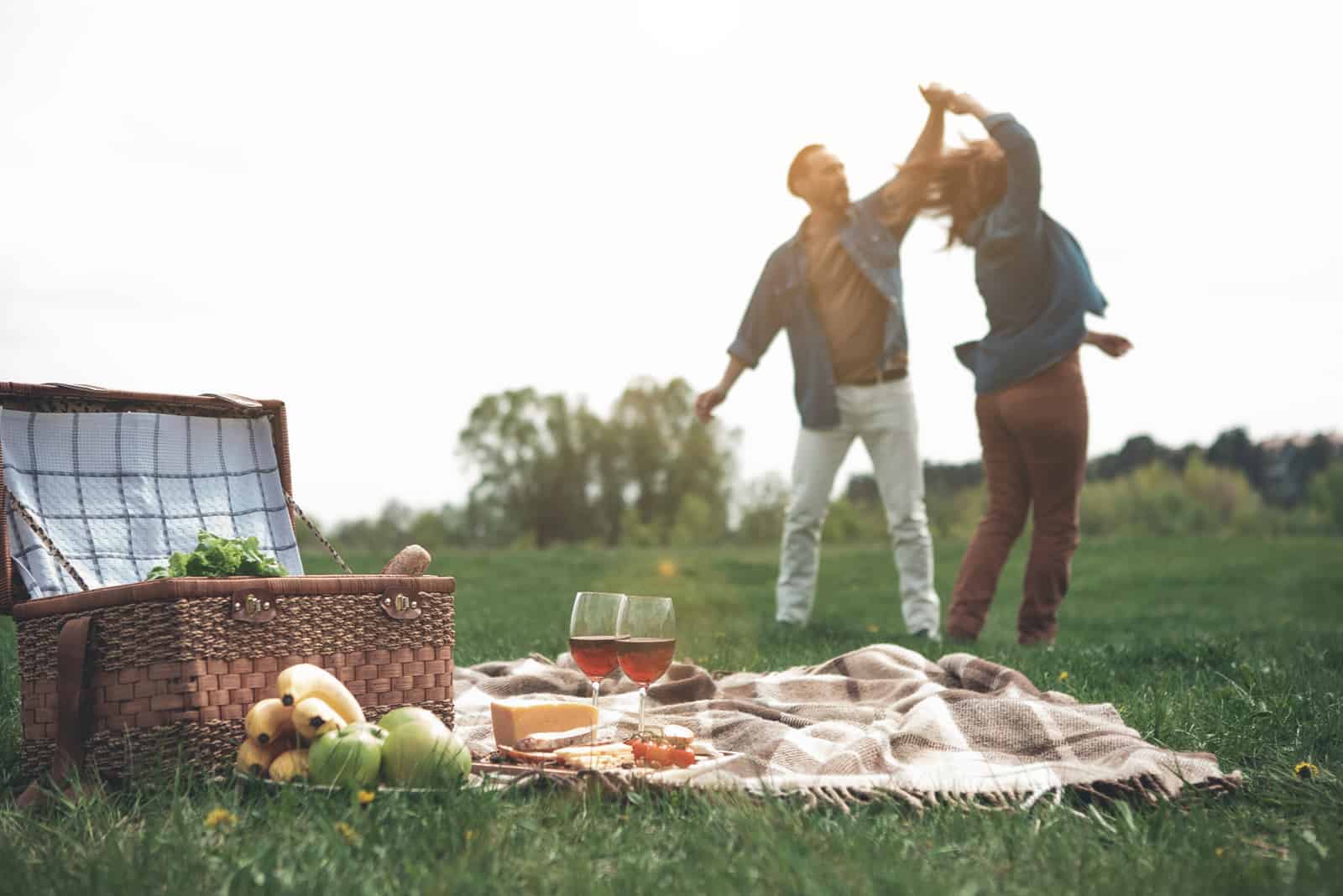 Bei einem Picknick in der Natur tanzt ein liebevolles Paar