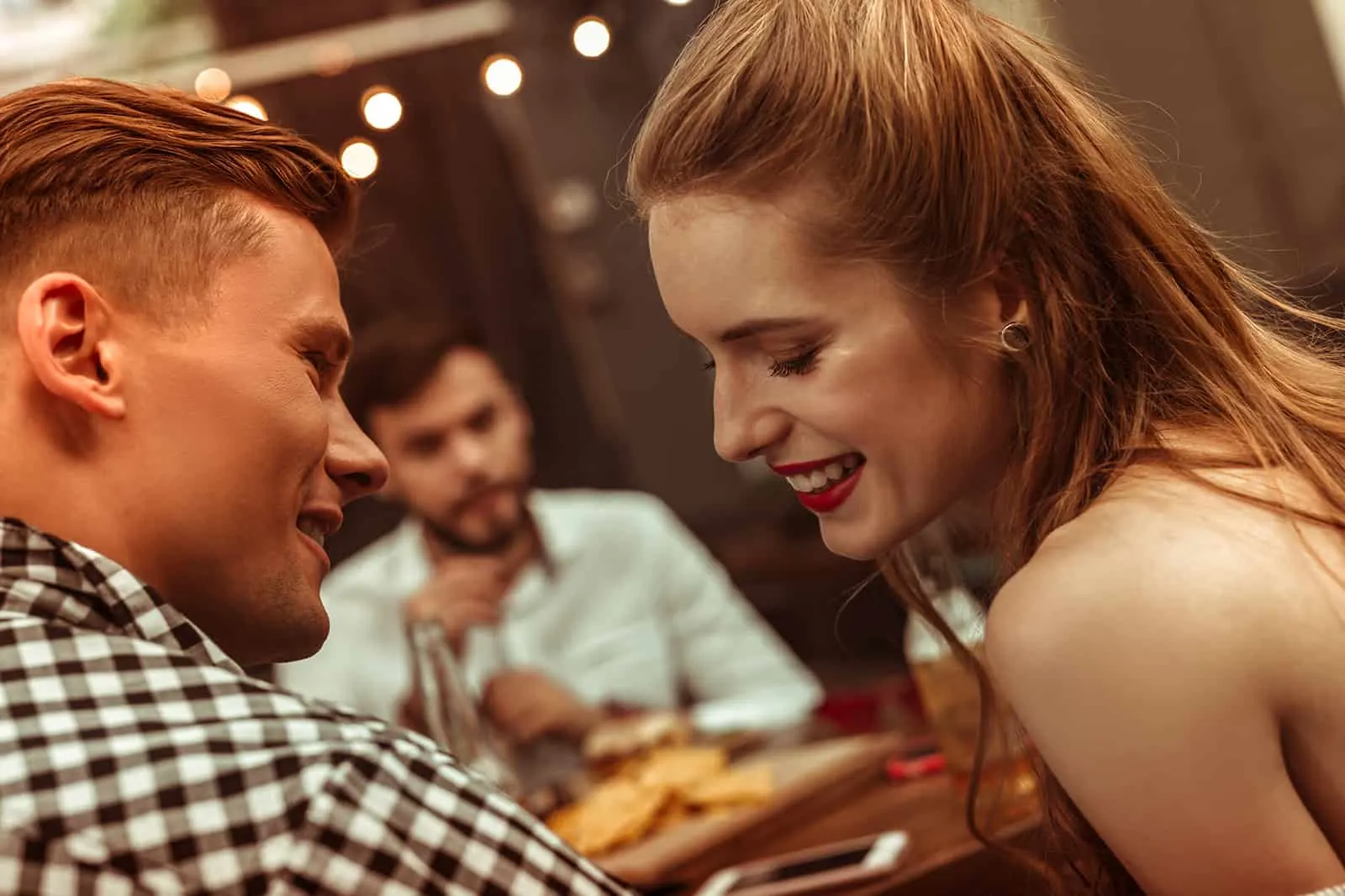 Ein Mann flirtet mit einer lächelnden Frau in der Bar