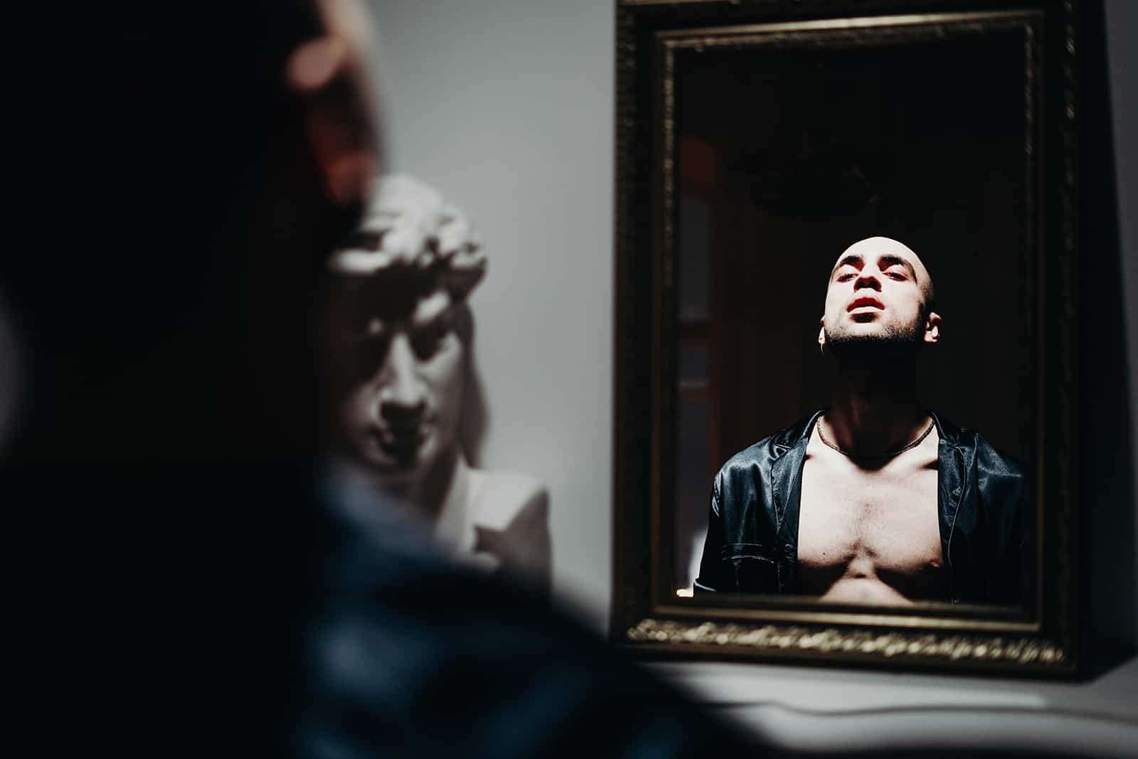 ein Mann, der vor dem Spiegel steht und sich selbst bewundert