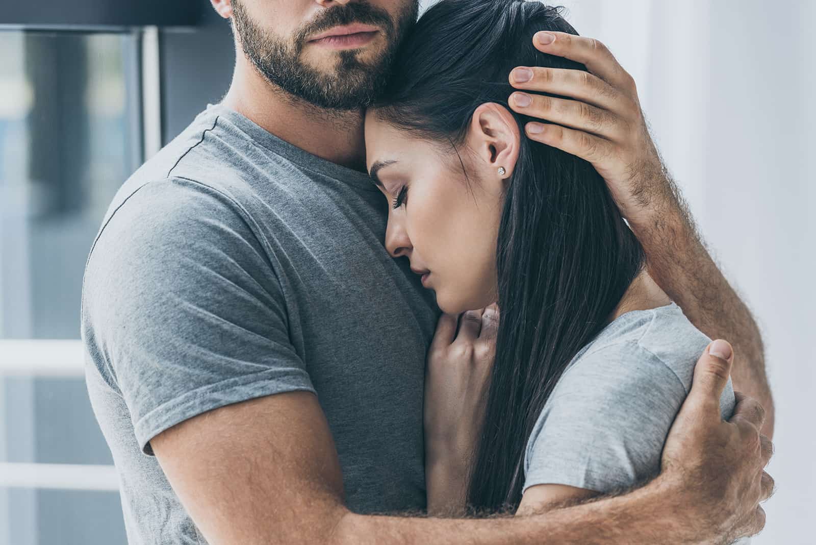 Ein Mann umarmt seine traurige Freundin und unterstützt sie