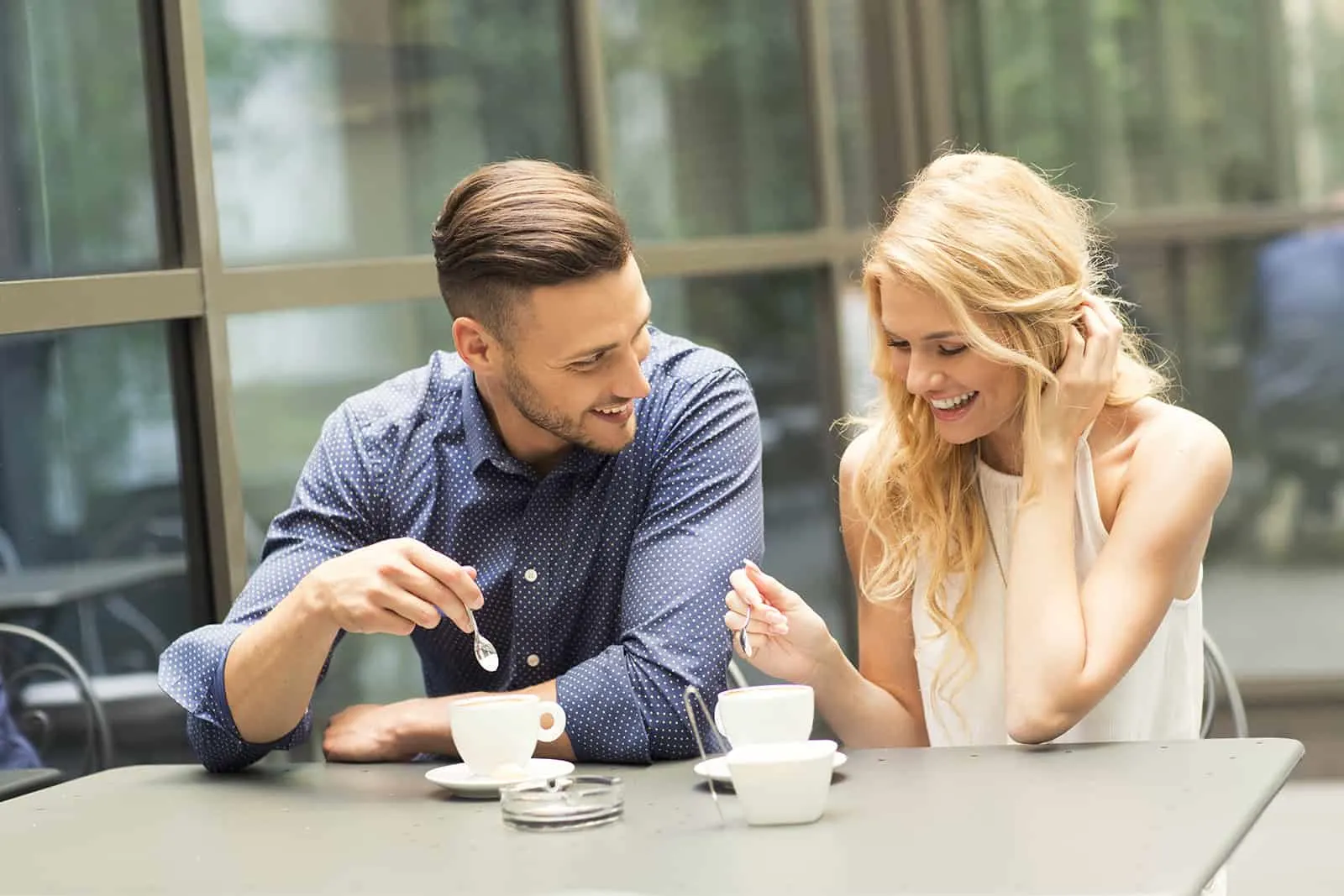 Ein Mann und eine Frau lachen über ein Date im Café