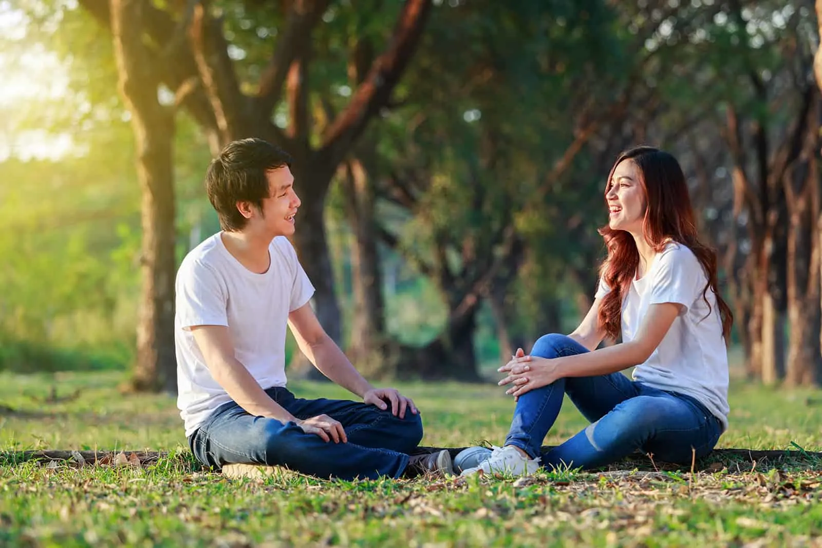 Ein Mann und eine Frau sitzen im Gras und reden