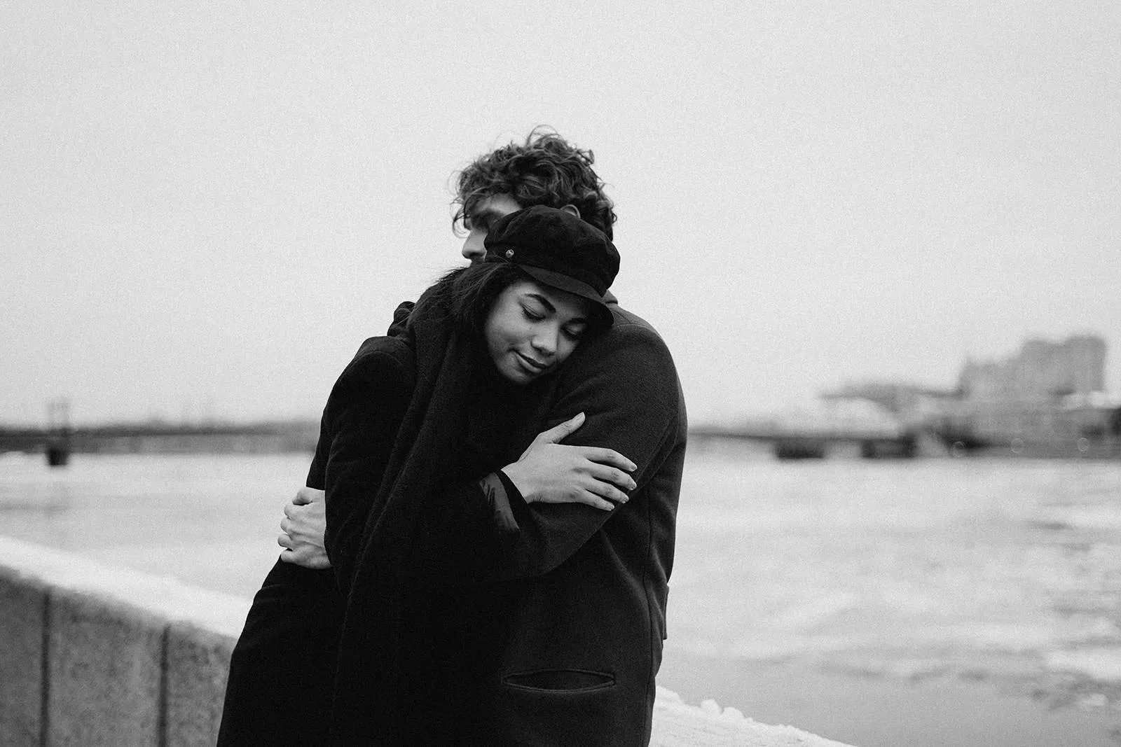 Ein Mann und eine Frau umarmen sich, während sie in der Nähe des Flusses stehen