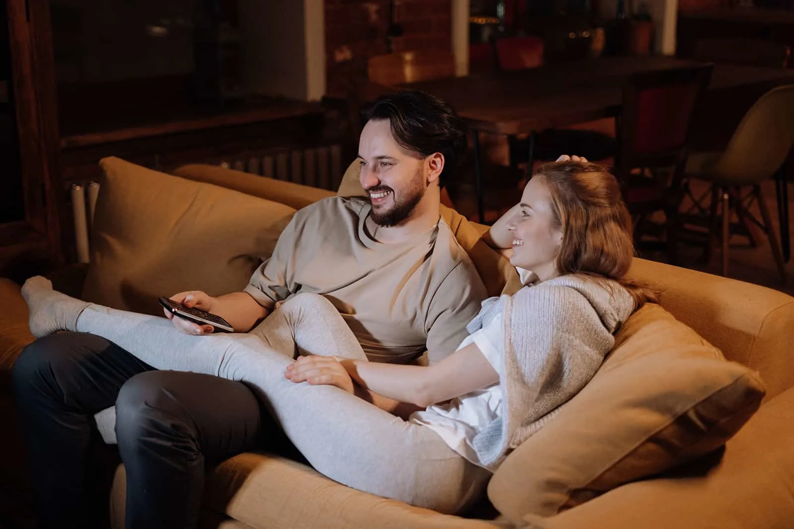 Ein glückliches Paar, das auf der Couch sitzt und über ihre Zukunftspläne spricht