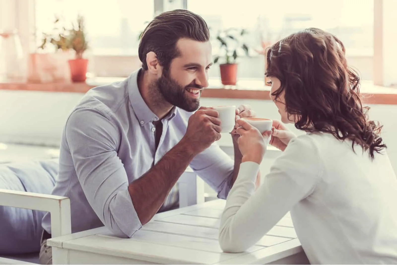 Ein lächelndes Paar flirtet bei einem Treffen in einem Café