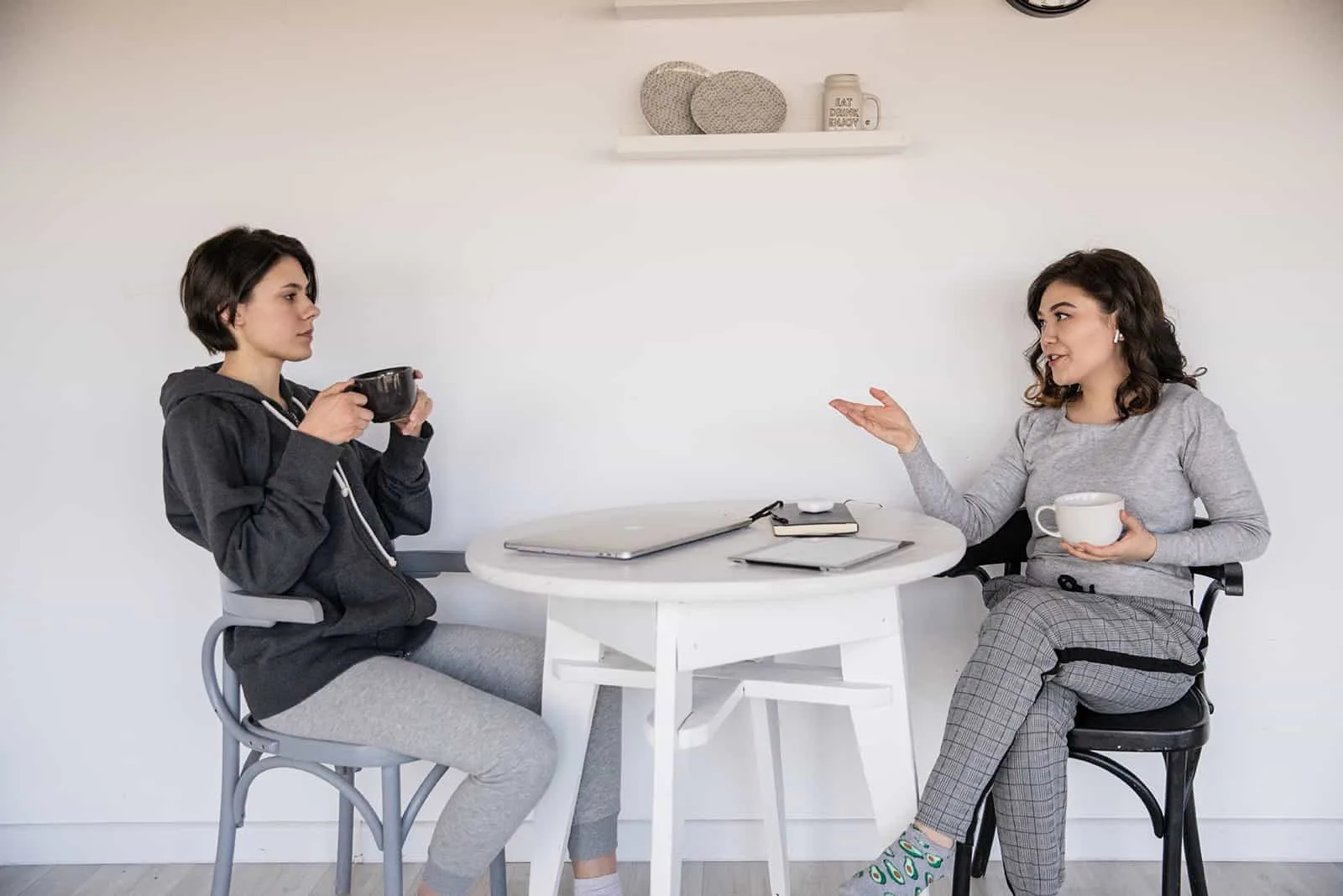 Frau spricht mit ihrer verärgerten Freundin, während sie zusammen Kaffee trinkt