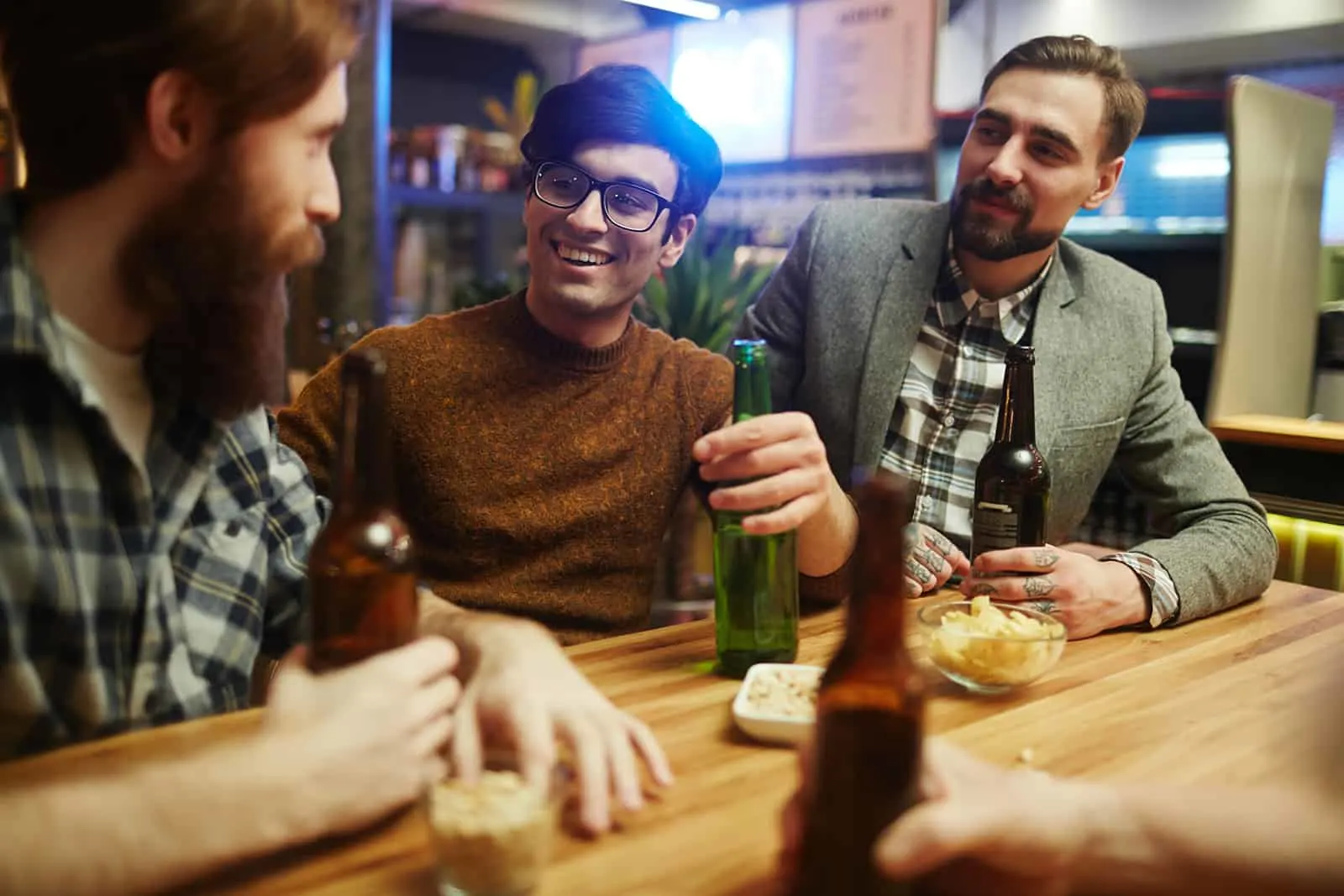 Gruppe von Freunden, die in der Kneipe sitzen und Bier trinken