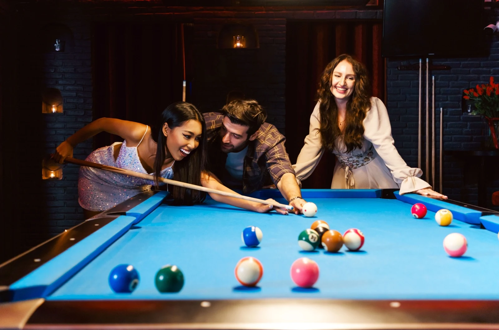 Mann flirtet mit Frau beim Billardspielen