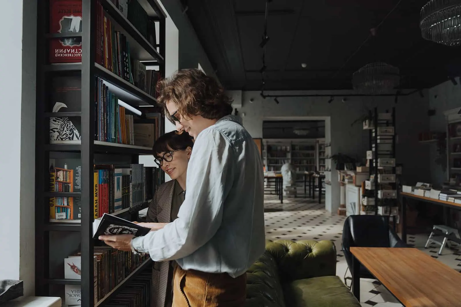 Mann und eine Frau, die ein Buch betrachten, während sie im Buchladen stehen
