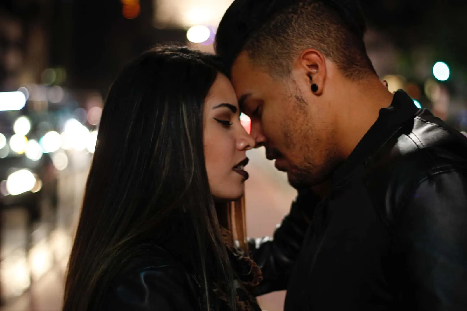 Ein Mann und eine Frau, die sich küssen wollen, stehen auf einer Straße