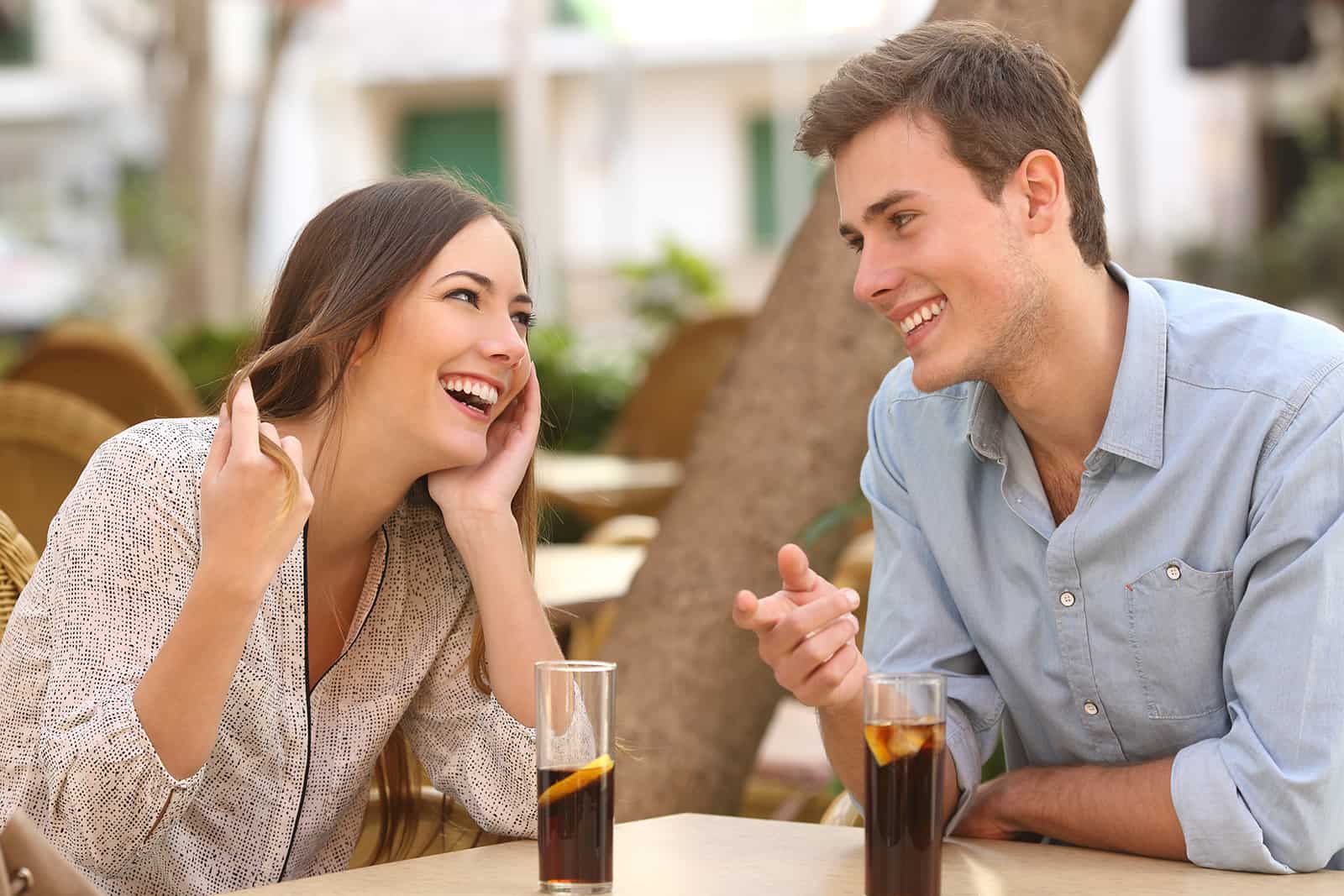 ein fröhliches Paar, das sich über ein Date im Café unterhält