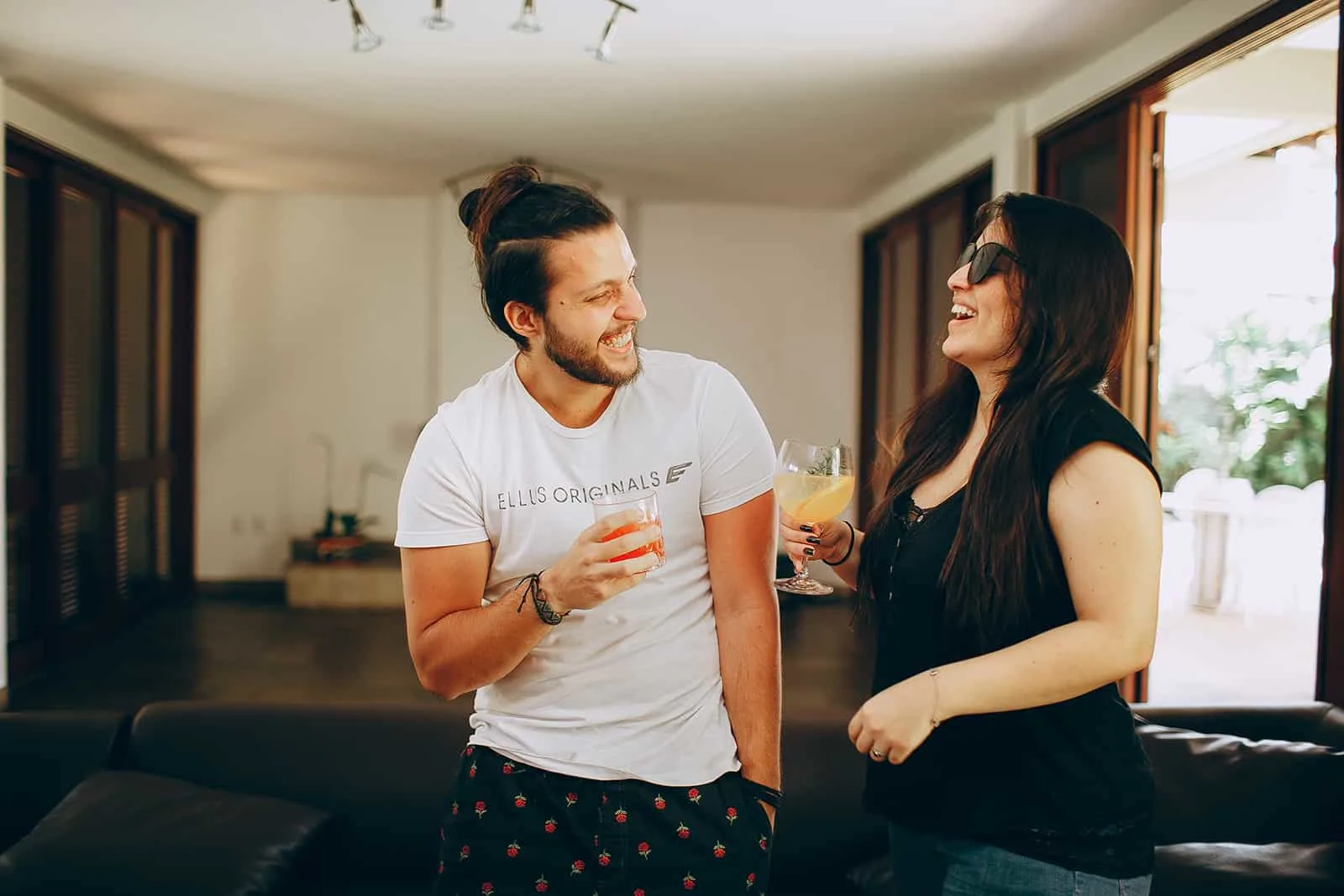 ein glückliches Paar, das zu Hause Cocktails trinkt