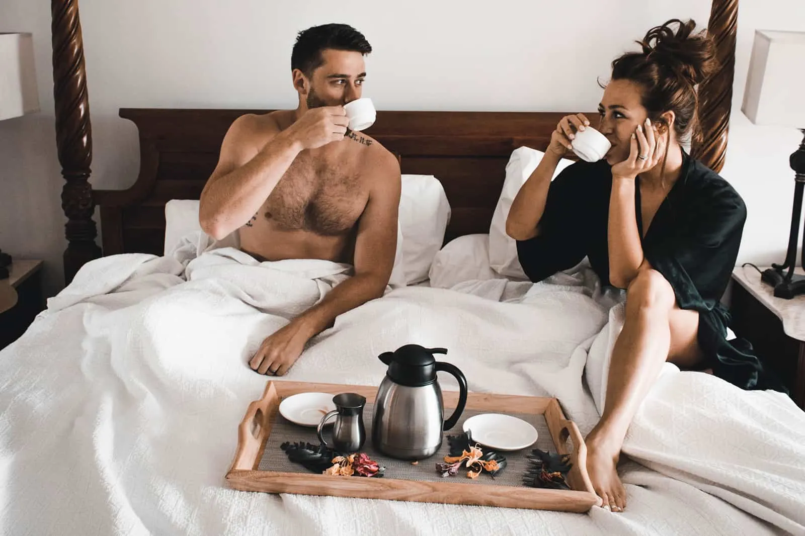 Ein liebevolles Paar trinkt morgens zusammen Kaffee im Bett