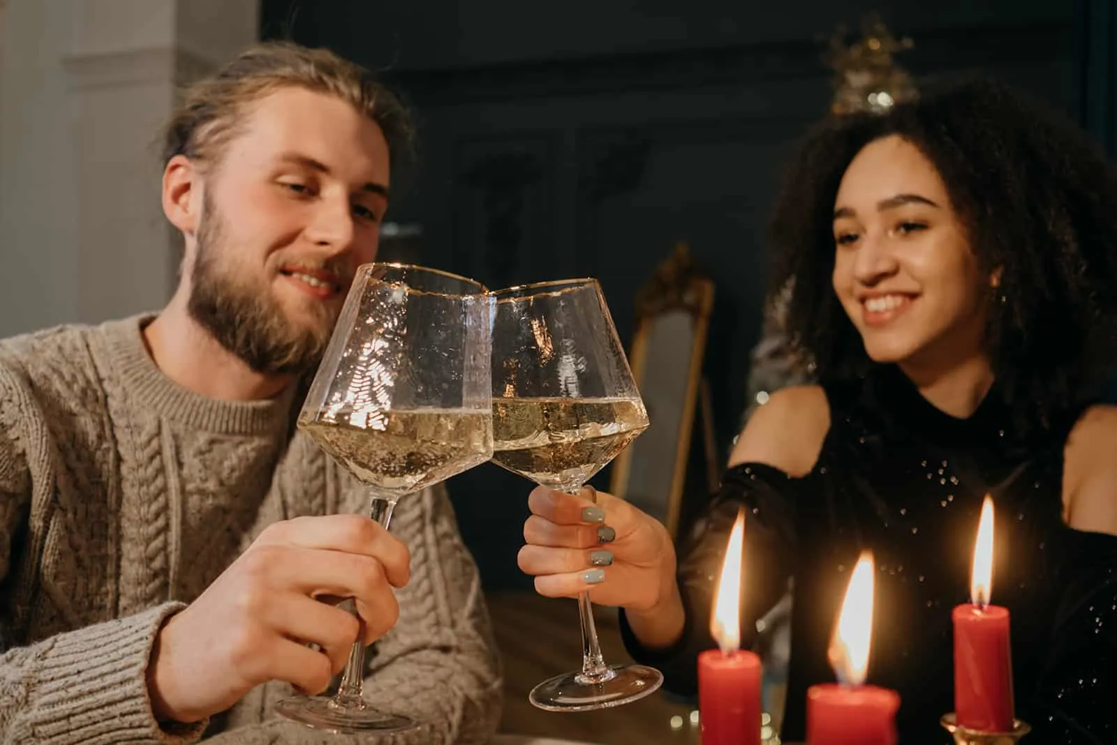 ein liebevolles Paar, das an einem romantischen Abend zu Hause mit Wein röstet