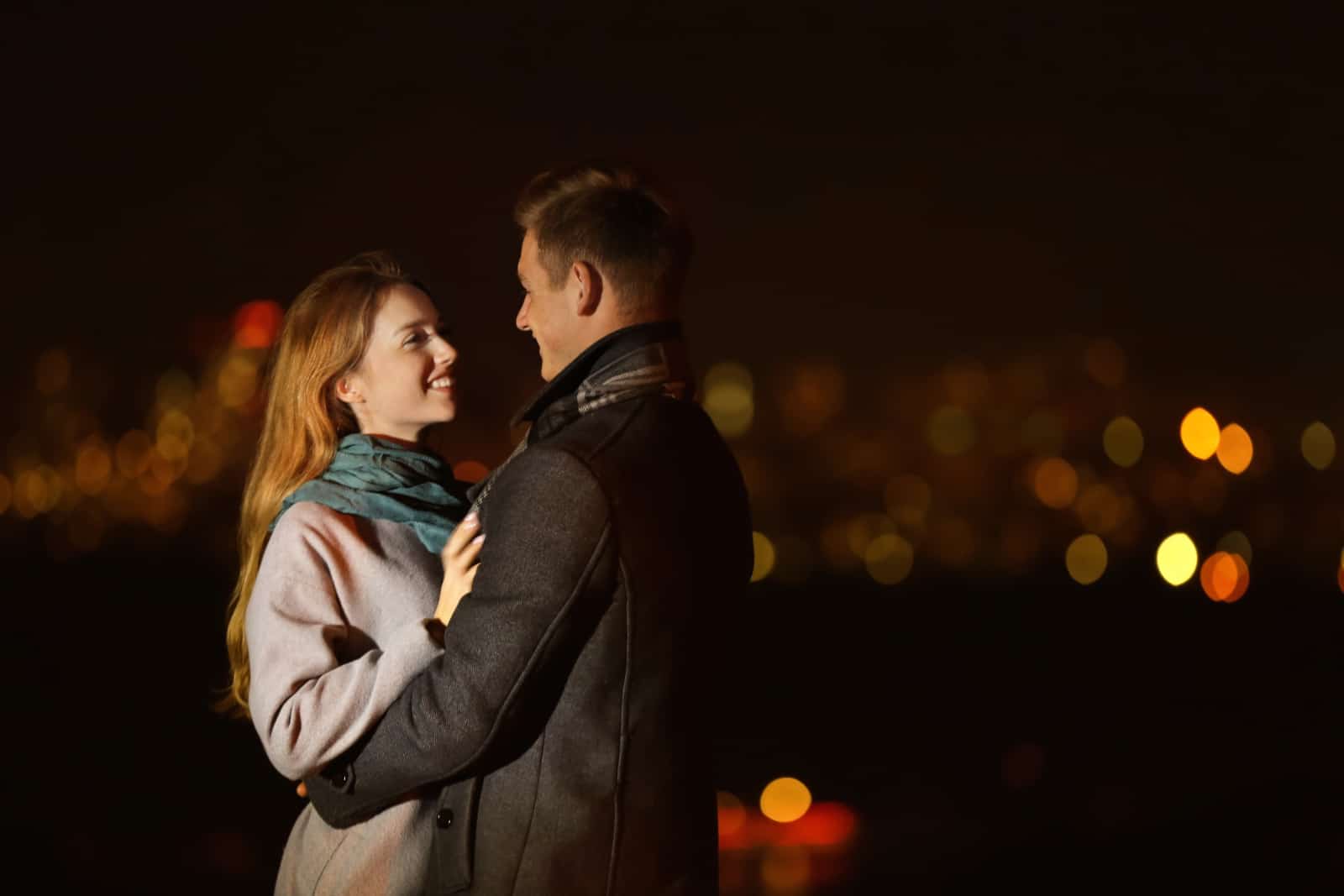 ein romantisches junges Paar, das sich nachts umarmt