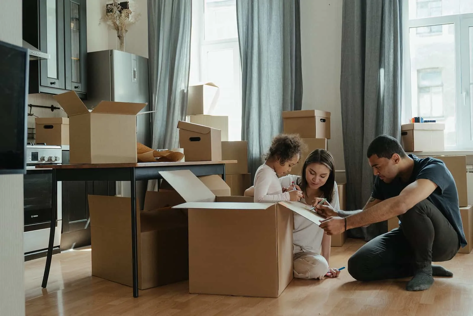 Eine Familie packt Kisten aus, nachdem sie in eine neue Wohnung gezogen ist