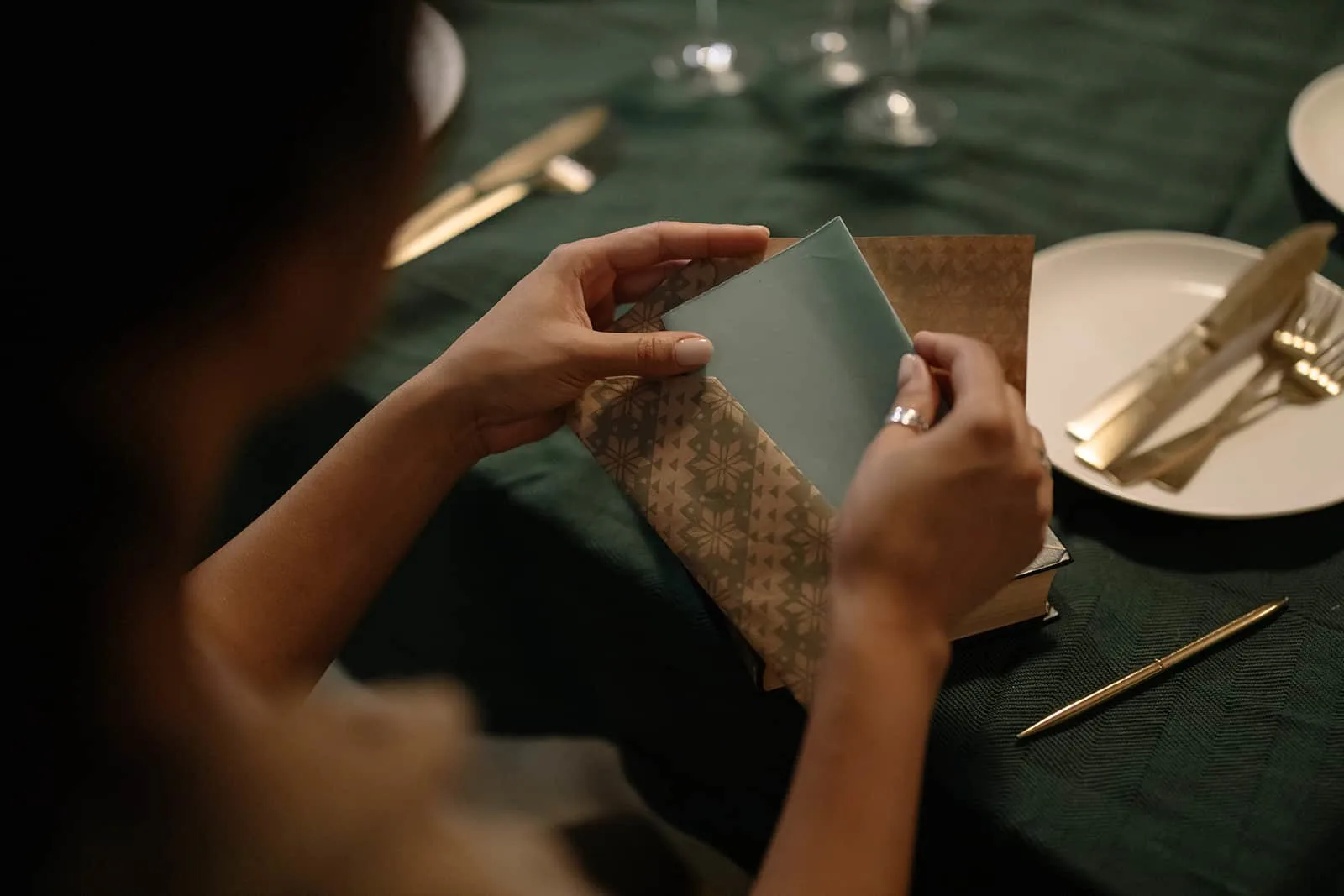 eine Frau, die einen Gutschein in einen Umschlag steckt, während sie am Tisch sitzt