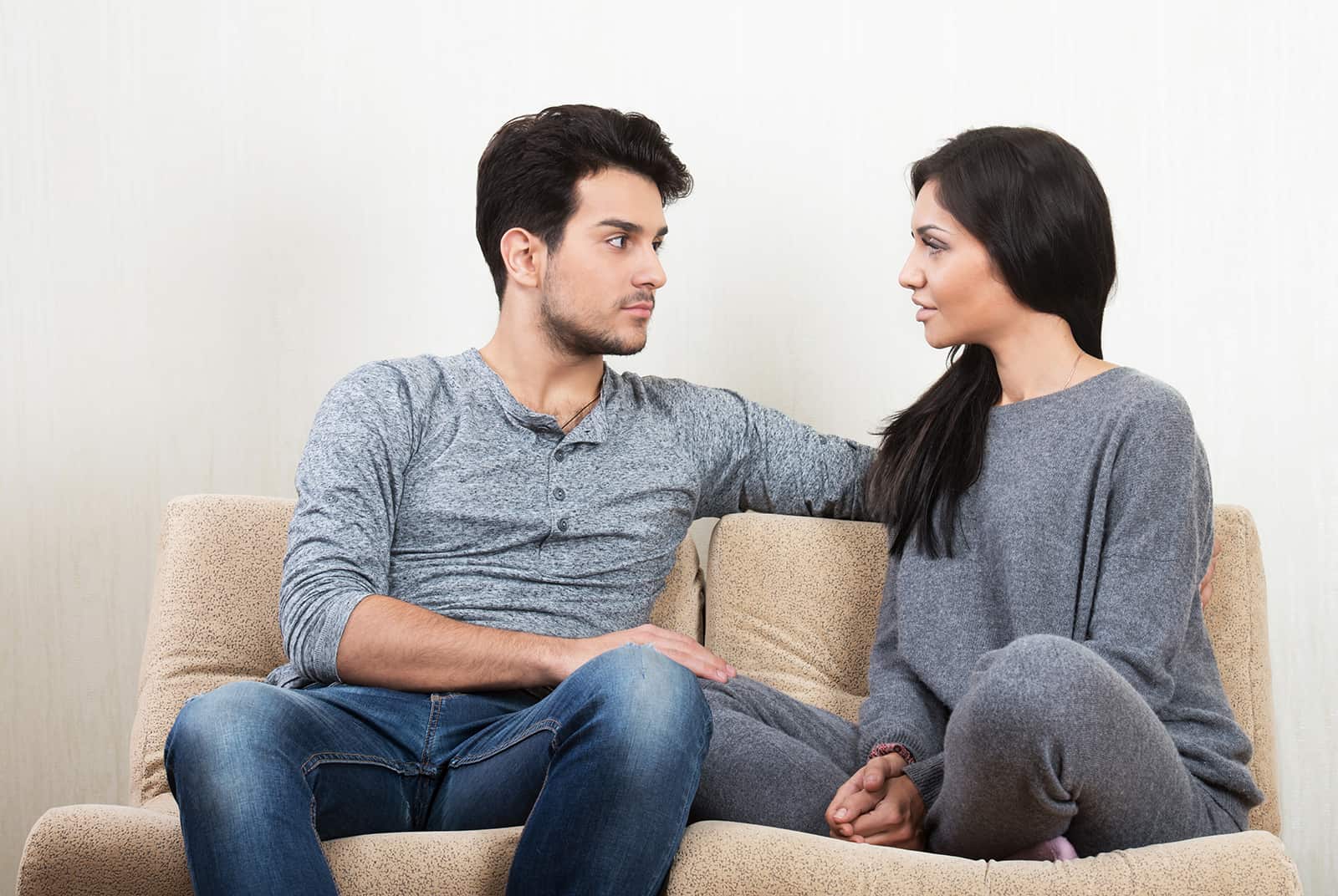 eine Frau, die ihren Freund um Rat fragt, während sie zusammen auf der Couch sitzt