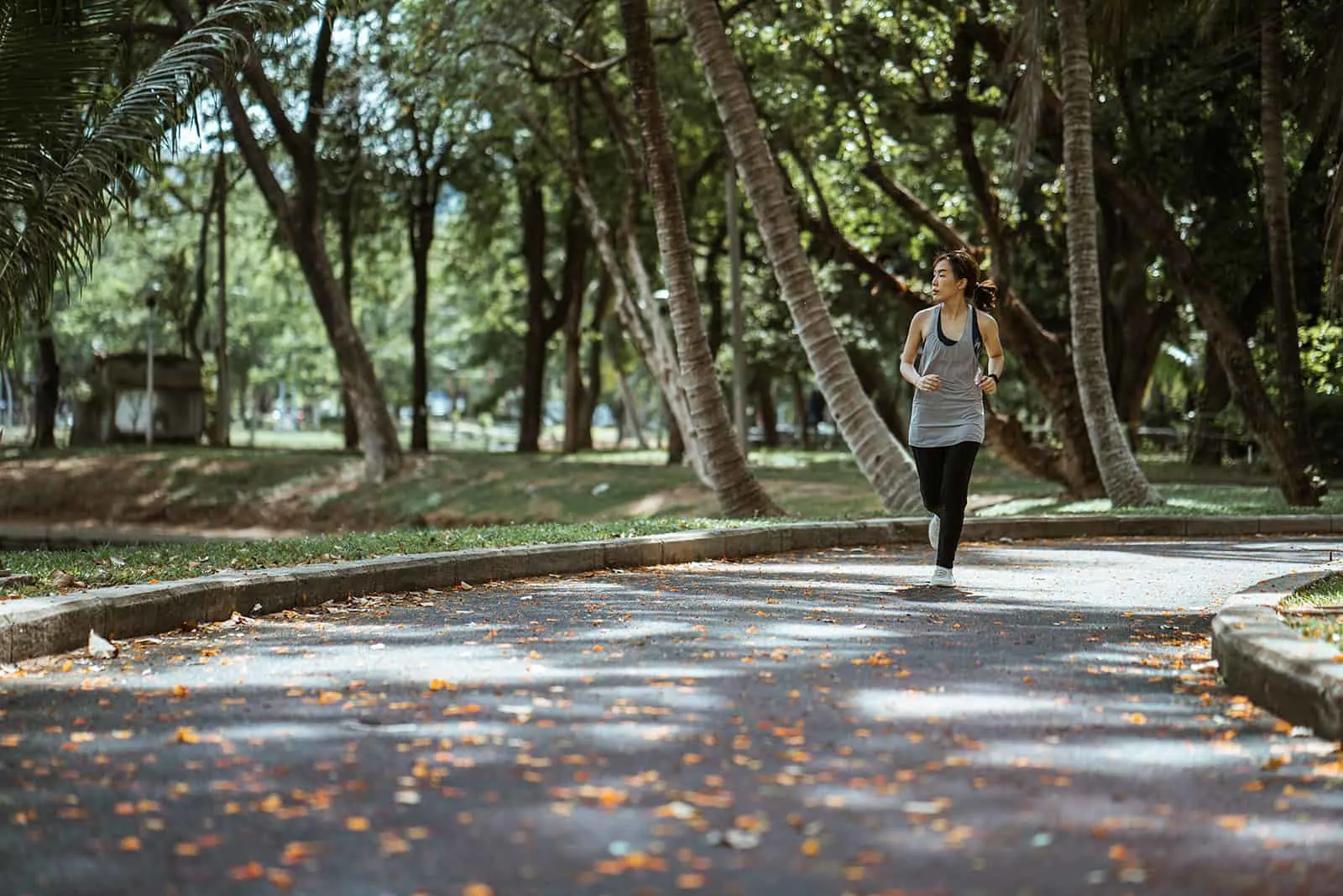 eine Frau, die in einem Park am sonnigen Tag joggt