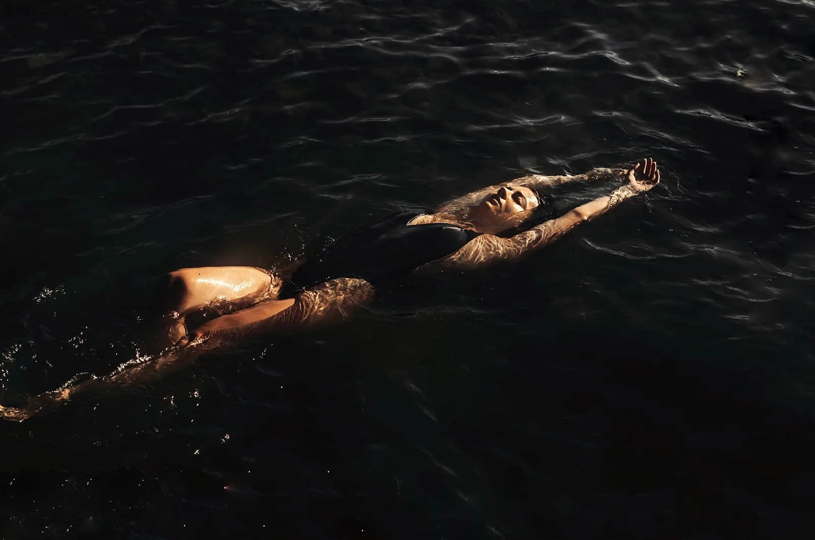 eine Frau schwimmt auf dem Rücken im See